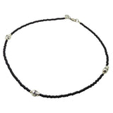Black glass bead necklace with silver skull charms on a white background. design by Dana Levy