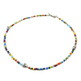 a multicolour and striped glass bead mix necklace with three silver plated brass skull charms and silver clasp. By Dana Levy