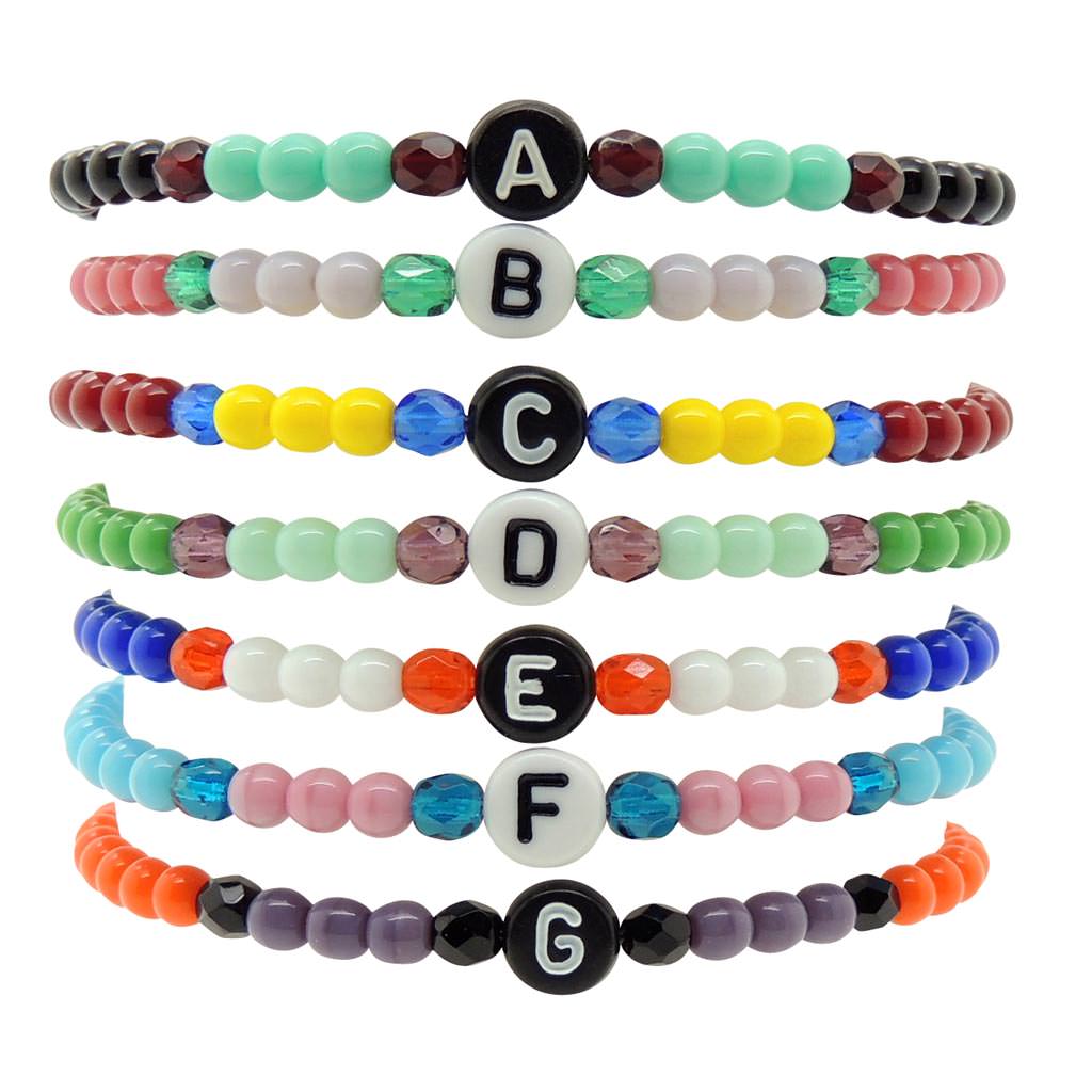 A Stack of Dana Levy Initial Letter Charm Glass Bead Mix Bracelets with the Letters A to G in a Variety of Colours.