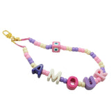 Dana Levy pastel coloured acrylic beaded phone charm strap with alphabet letters that read amour and a pastel pink evil eye cube charm with a gold clasp on a white background.