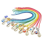 Dana Levy flat lay group of nautical cord necklaces with multicolour glass evil eyes and cowrie shell charms on a white background.