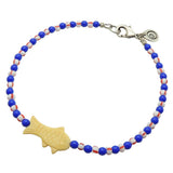 Dana Levy cream bone fish charm striped glass bead mix anklet with royal blue glass beads and white/red striped glass beads and an antique silver plated clasp on a white background. 