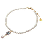 A Dana Levy white freshwater pearl necklace with a gold-tone clasp and extender chain, featuring an evil eye hamsa hand shaped charm with a dangling pearl bead, on a white background.