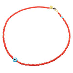 A Dana Levy tomato red glass rocaille bead necklace with opaque turquoise evil eye charms on a white background. 