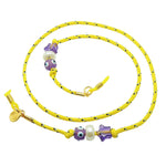 Dana Levy yellow eyeglass cord with purple lucky charm beads on a white background