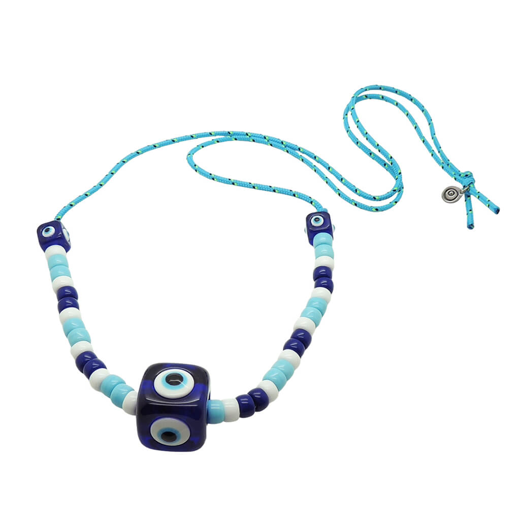 Dana Levy royal blue evil eye cube charms and turquoise white and navy glass beads on a turquoise nautical cord necklace on a white background. 