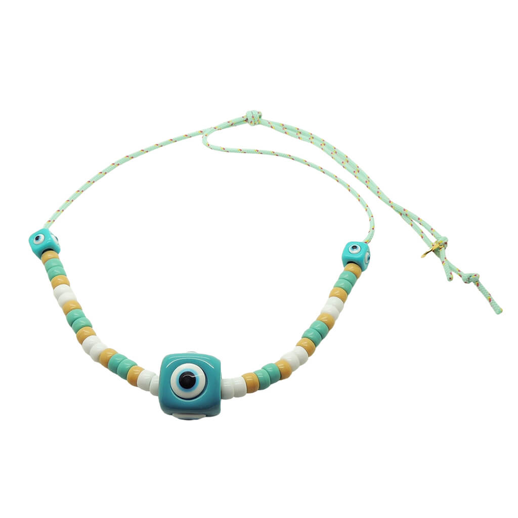 Dana Levy aqua evil eye cube charms with white, aqua and beige glass candy beads on a mint cord necklace on a white background. 
