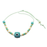 Dana Levy aqua evil eye cube charms with white, aqua and beige glass candy beads on a mint cord necklace on a white background. 