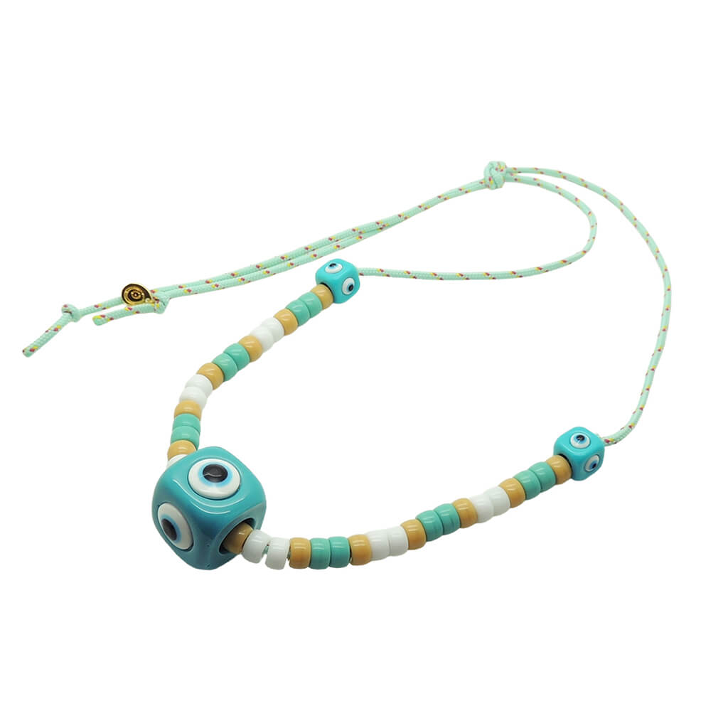 Dana Levy aqua evil eye amulet cubes and aqua, white and beige glass beads on a mint cord necklace on a white background. 