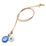 Dana Levy evil eye disc duo leather cord necklace with large blue and small white evil eye charms on natural leather cord on a white background. 