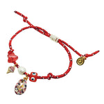 Dana Levy red nautical cord bracelet with various lucky charms on a white background.