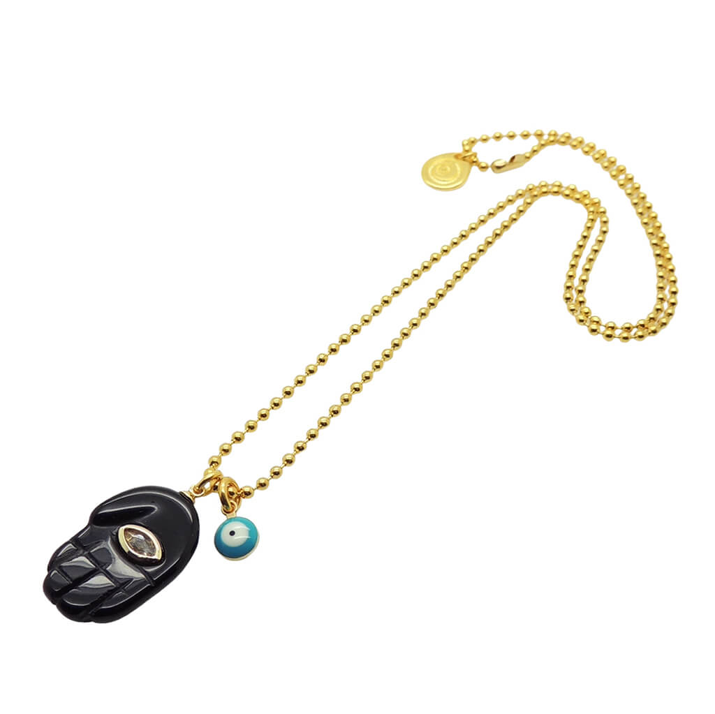 Dana Levy gold plated ball chain necklace with a black hamsa hand diamante pendant and blue evil eye charm on a white background