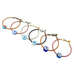 Dana Levy six braided leather cord bracelets with chunky glass evil eye bead charms in various colours, arranged diagonally on a plain white background.