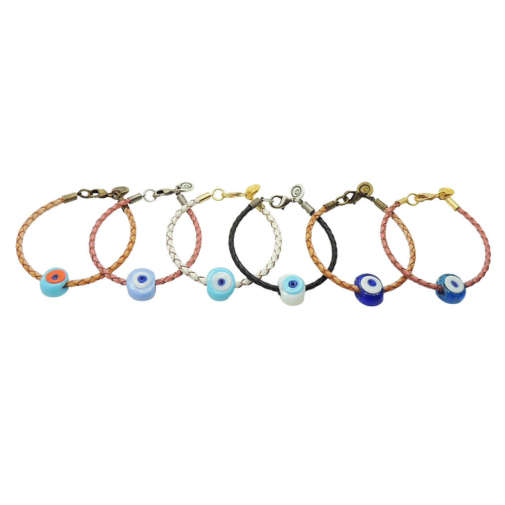 Dana Levy six braided leather cord bracelets with chunky glass evil eye amulets, displayed in a row against a plain white background. The cords are in tan brown, pink, white, and black tones, and the evil eye amulets are in various shades of blues and white.