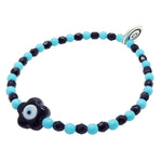 Dana Levy Black glass evil eye flower charm glass bead mix bracelet with  opaque turquoise beads and jet black faceted glass beads on white background. 