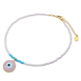 a Dana Levy glass bead choker with baby pink, white and turquoise glass rocaille beads with a pastel pink glass evil eye disc pendant on a white background. 