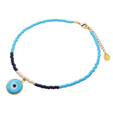A Dana Levy glass beaded necklace with turquoise, cream and dark navy beads, featuring a round turquoise blue and white evil eye pendant charm and a gold-tone chain extender clasp on a plain white background.