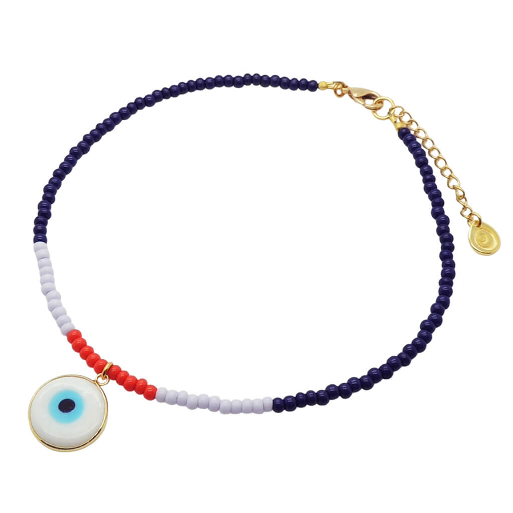 A Dana Levy glass bead choker featuring navy blue, lilac, and red beads, with a gold-tone clasp and extender chain. A round white glass evil eye pendant with a blue centre and gold bezel is attached near the front.