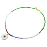 A Dana Levy glass beaded necklace featuring a white evil eye disc pendant, with sections of green, white, light blue, and dark brown beads, finished with a gold plated clasp.