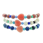 Dana Levy trio of pink heart charm gemstone bracelets with rainbow glass beads stacked on white background. 