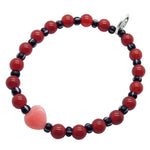 Dana Levy pink jade heart gemstone bracelet with large red carnelian gemstone beads and black striped glass beads on a white background. 