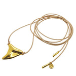 Dana Levy large gold plated shark tooth amulet charm natural leather cord lariat necklace with gold cord ends on a white background. 