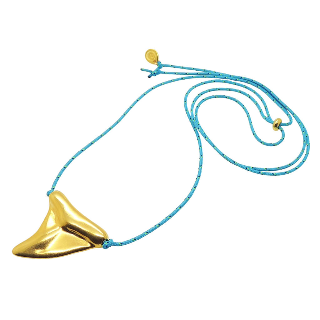 Dana Levy gold plated large shark tooth amulet on a turquoise nautical cord necklace on a white background. 
