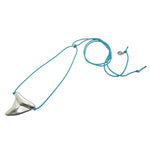 Dana Levy silver plated oversized shark tooth amulet on a turquoise nautical cord necklace, on a white background. 