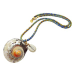 Dana Levy large spiral seashell charm with a small cowrie shell charm on a blue green and brown braid cord necklace on a white background. 