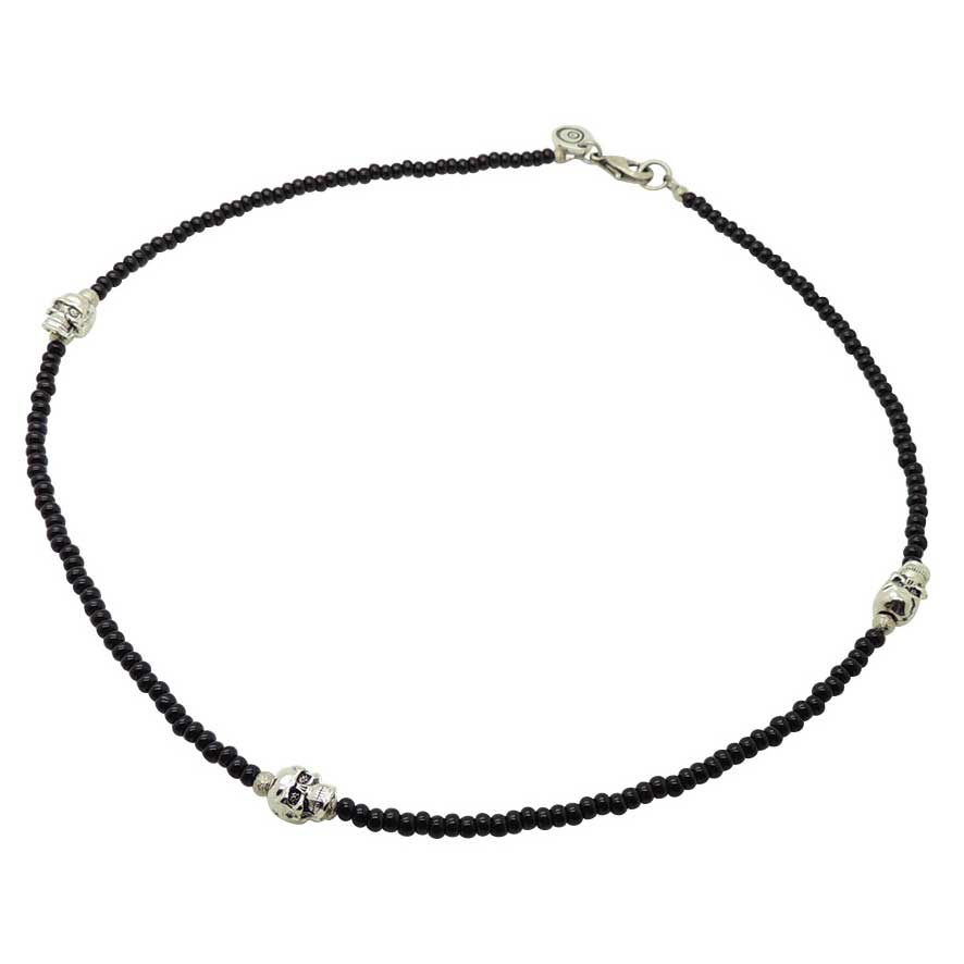 Black glass bead necklace with silver skull charms on a white background. design by Dana Levy 