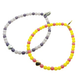 Dana Levy two colourful glass beaded bracelets with a silver and gold heart on a white background.