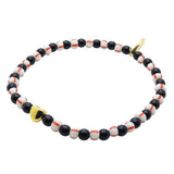 Dana Levy bracelet with a gold plated heart charm, and black, white, and red striped glass beads on a white background.