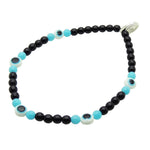 Dana Levy bracelet with black and turquoise blue glass beads, and white evil eye beads on a white background