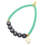 A Dana Levy aqua coloured newborn baby milestone glass bead bracelet with birth date in black acrylic letters and a gold plated mini boy icon charm, on a white background. 