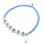 A Dana Levy light cornflower blue newborn baby milestone glass bead bracelet with birth date in acrylic letters and a silver plated mini boy icon charm, on a white background. 