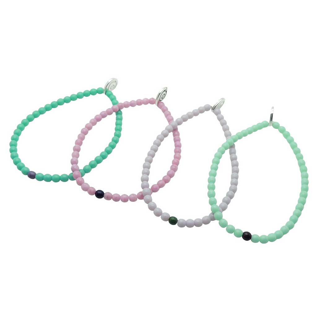 Dana Levy Set of four glass beaded bracelets in green, pink, grey, and light mint green on a white background