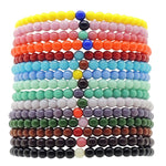Stack of colourful Dana Levy glass beaded bracelets on a white background