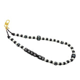 Dana Levy black and white beaded phone charm strap with 'CALL ME' beads on a white background