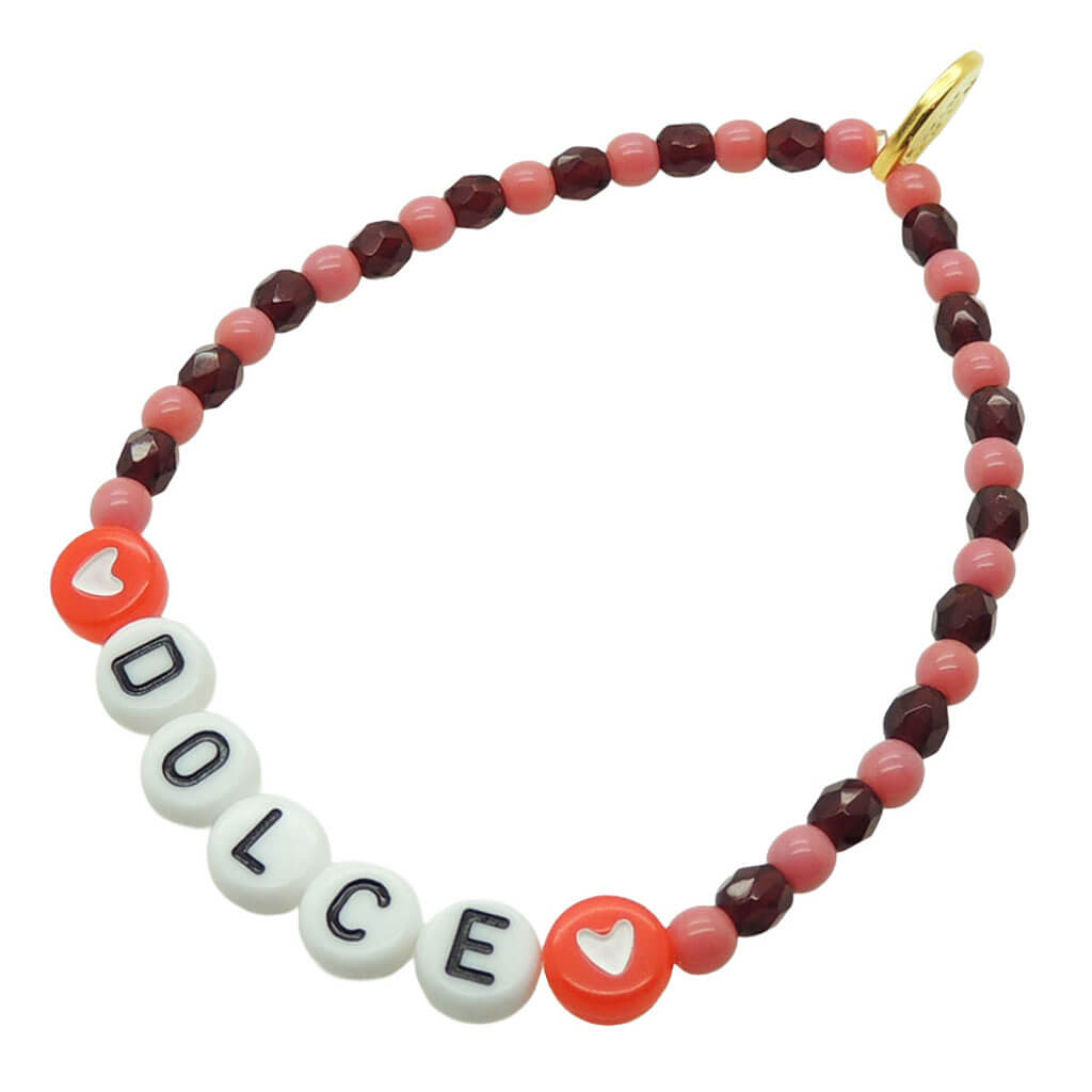 Dana Levy DOLCE personalised name glass crystal bead mix bracelet with rose pink and wine red glass beads and red heart charms on a white background. 