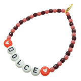 Dana Levy DOLCE personalised name glass crystal bead mix bracelet with rose pink and wine red glass beads and red heart charms on a white background. 