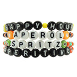 Dana Levy set of personalised name glass crystal bead mix bracelets spelling out 'Happy Hour Aperol Spritz Aperitivo' on a white background.