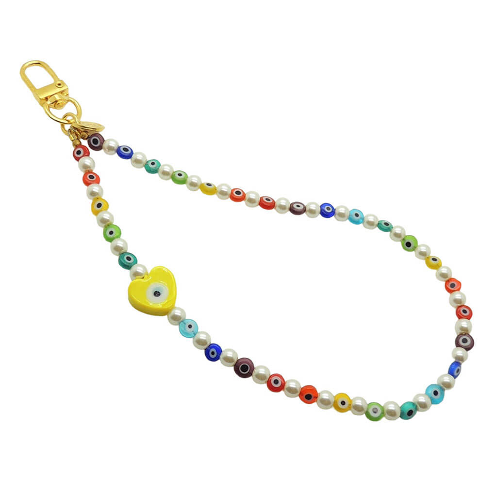Dana Levy rainbow glass evil eye heart faux pearl beaded phone wristlet strap with a yellow evil eye heart charm on a white background.