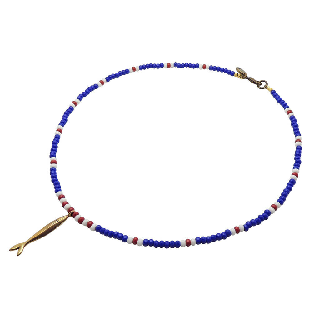 Dana Levy sardine charm striped glass bead necklace with an antique gold sardine charm pendant and royal blue white red glass beads on a white background. 