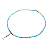 Dana Levy sardine charm striped glass bead necklace with an antique silver sardine charm pendant and turquoise white and dark brown glass beads on a white background. 