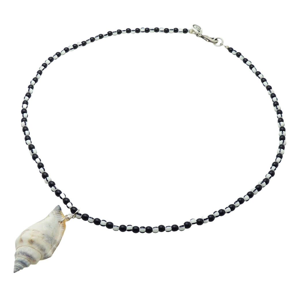 Dana Levy necklace with black and white stripe glass beads and a conch seashell pendant on a white background.