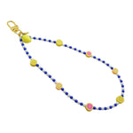 Dana Levy Sicilian tutti frutti charm two tone glass bead phone wristlet strap with fruit mix, royal blue and white glass bead mix on a white background.