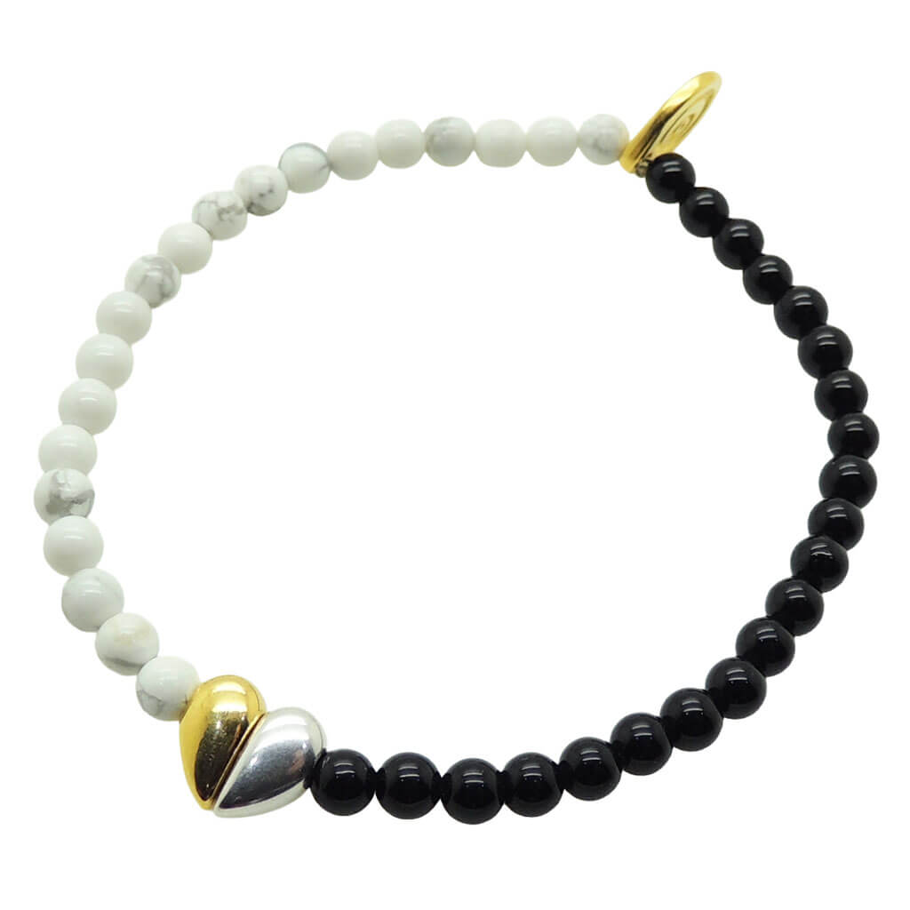 Dana Levy split heart charm gemstone bracelet with howlite beads on one side and black onyx beads on the other on a white background.