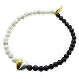 Dana Levy split heart charm gemstone bracelet with howlite beads on one side and black onyx beads on the other on a white background.