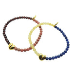 Dana Levy two gold split heart charm gemstone bead bracelets in garnet rhodonite and aragonite lapis lazuli gemstones on a white background.