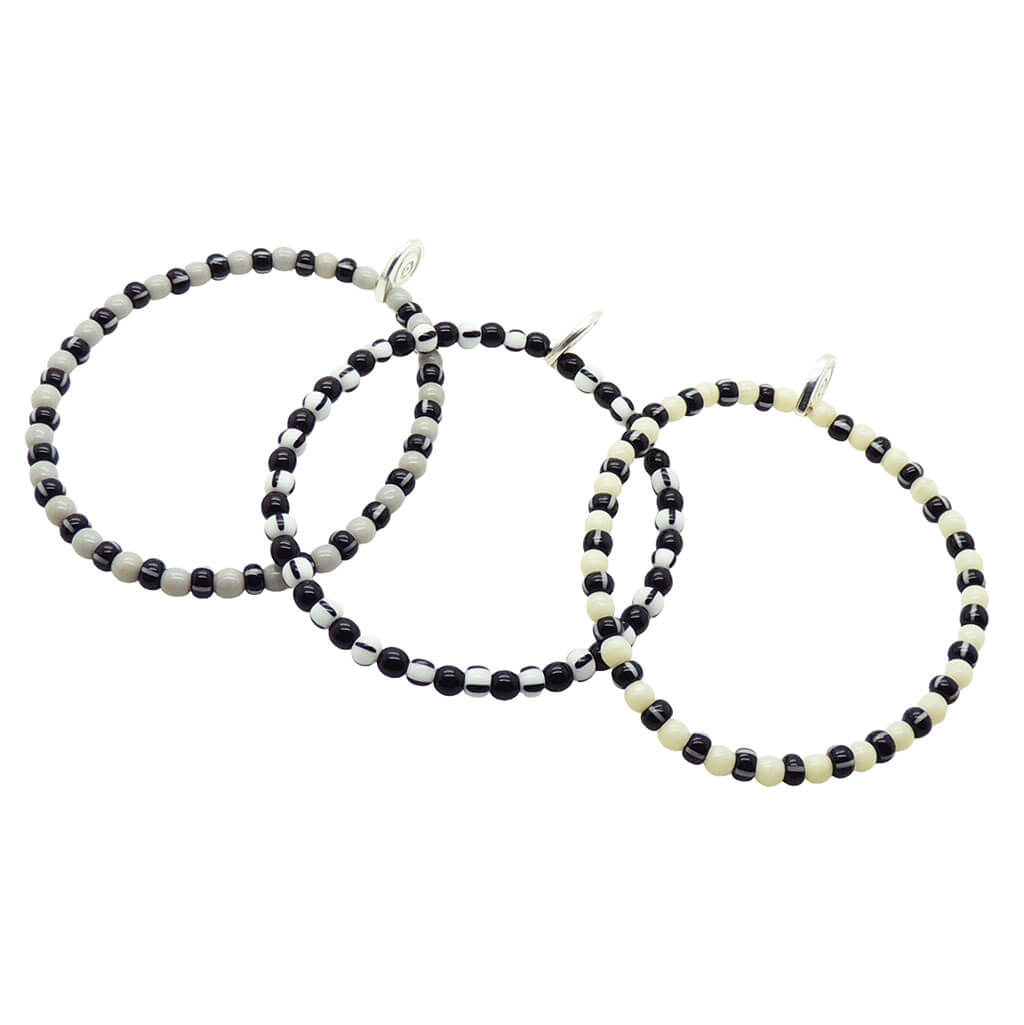 Dana Levy trio of grey, black and ivory striped glass beaded bracelets on a white background.